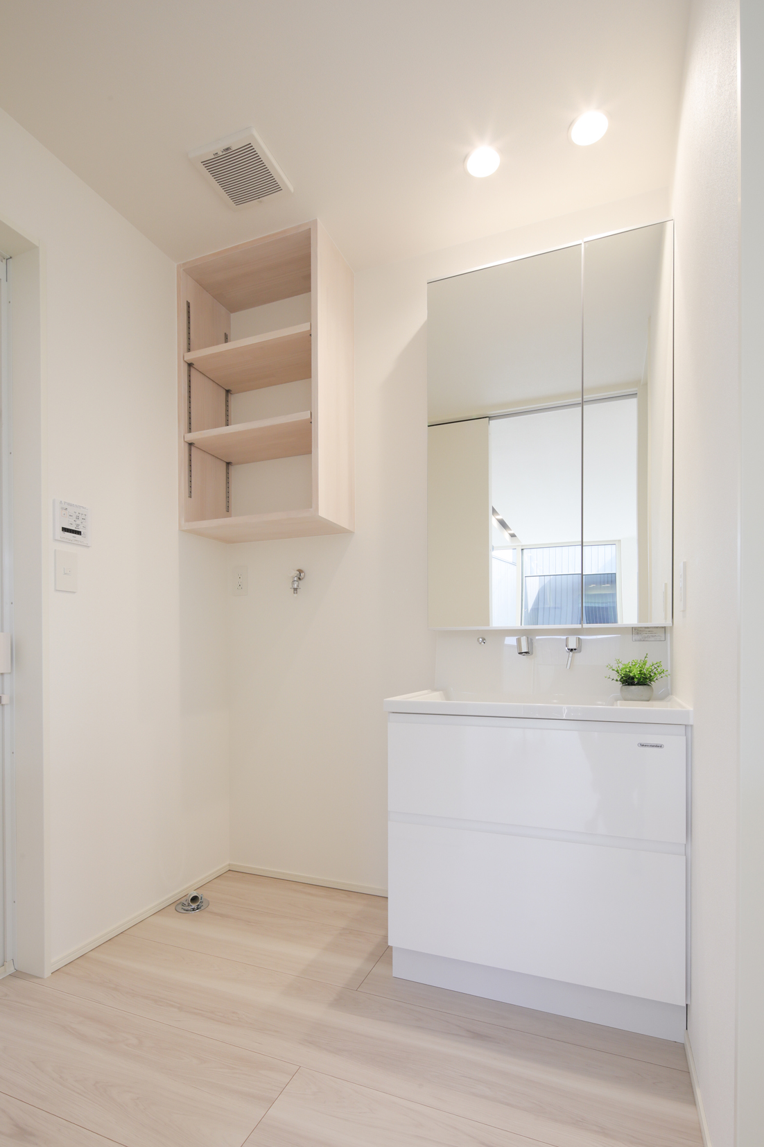 【洗面室】清潔感のある洗面室。洗濯機上部にしっかり収納できる造作棚つき